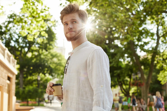 Ein Mann in einem weißen Sommerhemd genießt den Tag in der Stadt – stilvoll, leicht und ideal für Spätsommertage.