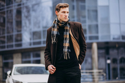 Mann mit elegantem Wintermantel und Schal; klares, minimalistisches Winteroutfit für kalte Tage.