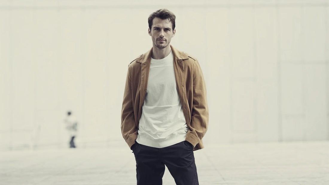 Mann in Camel-Jacke und weißem T-Shirt mit selbstbewusstem Blick – Stil vs Trend, persönlicher Männerstil der bleibt, Huberd