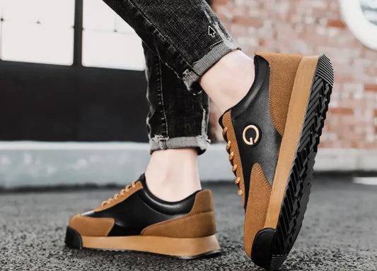 Minimalistische Sneaker aus Leder und Wildleder in Schwarz und Braun, getragen mit Jeans – vielseitiger Winterschuh 2025 von Huberd